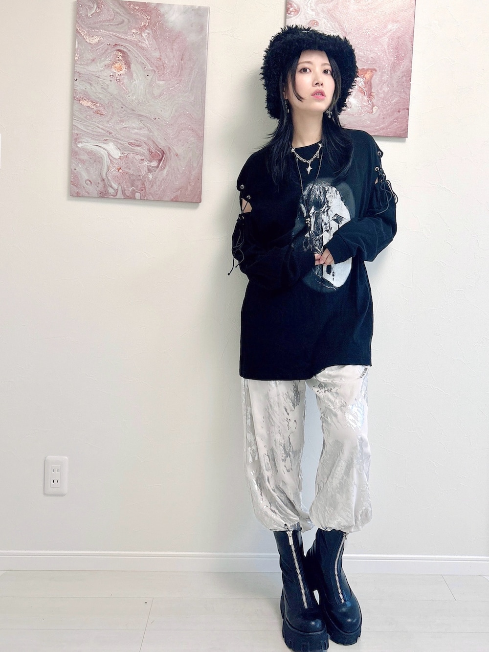 ブラック系のTシャツ/カットソー、ホワイト系のパンツ、ブラック系のブーツを着用したレディースの秋コーディネートの2枚目の写真