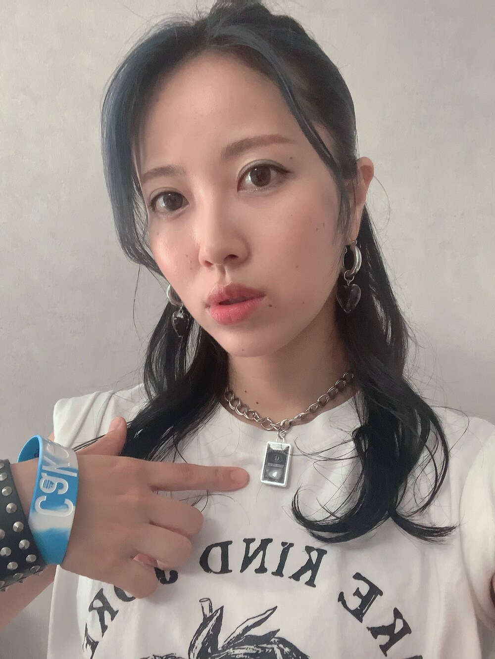 ホワイト系のTシャツ/カットソー、ブラック系のスカート、ブラック系のブーツを着用したレディースの夏コーディネートの2枚目の写真