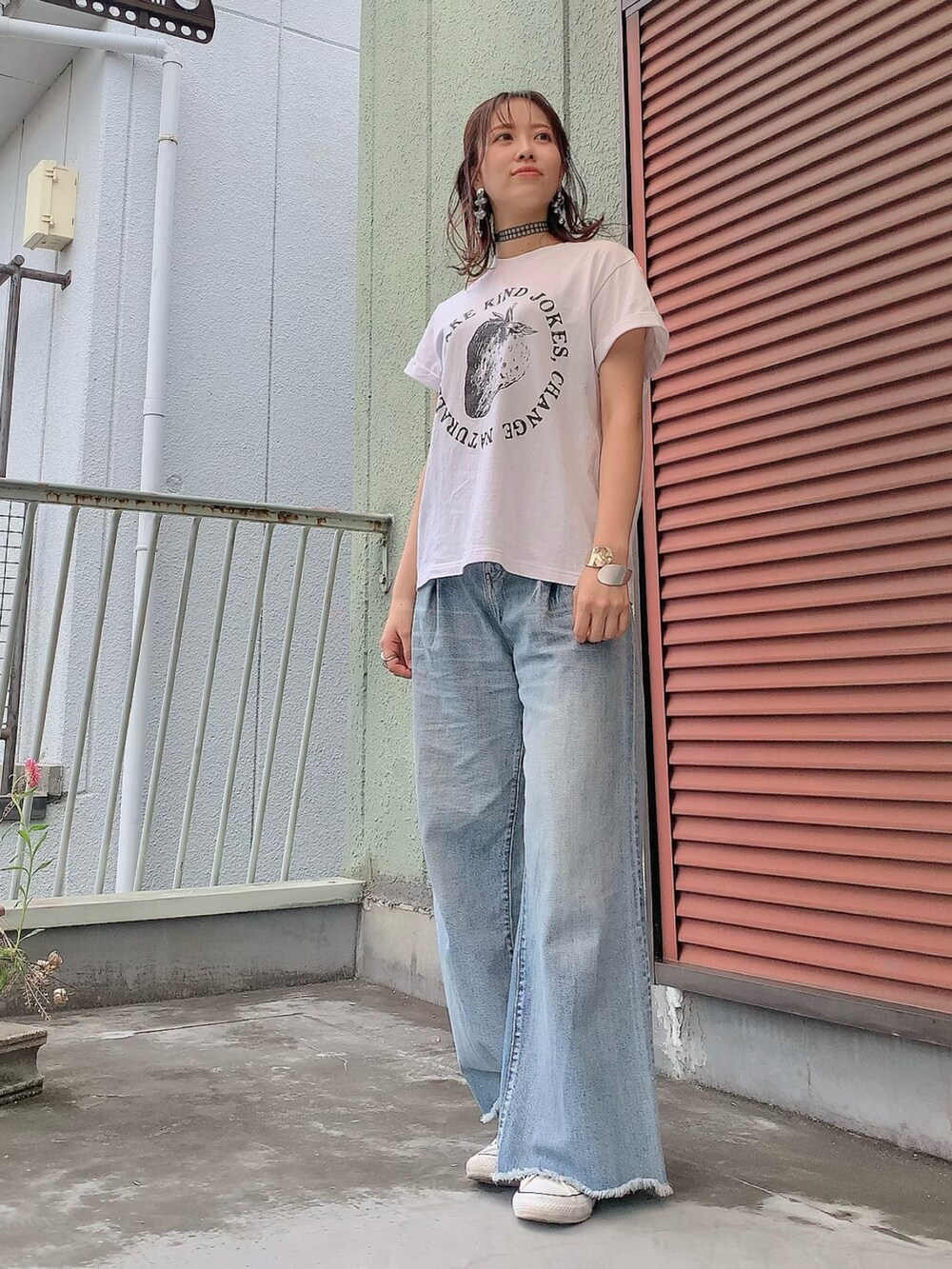 ブラック系のパーカー、ブルー系のデニムパンツ、ベージュ系のスニーカーを着用したレディースの春コーディネートの2枚目の写真