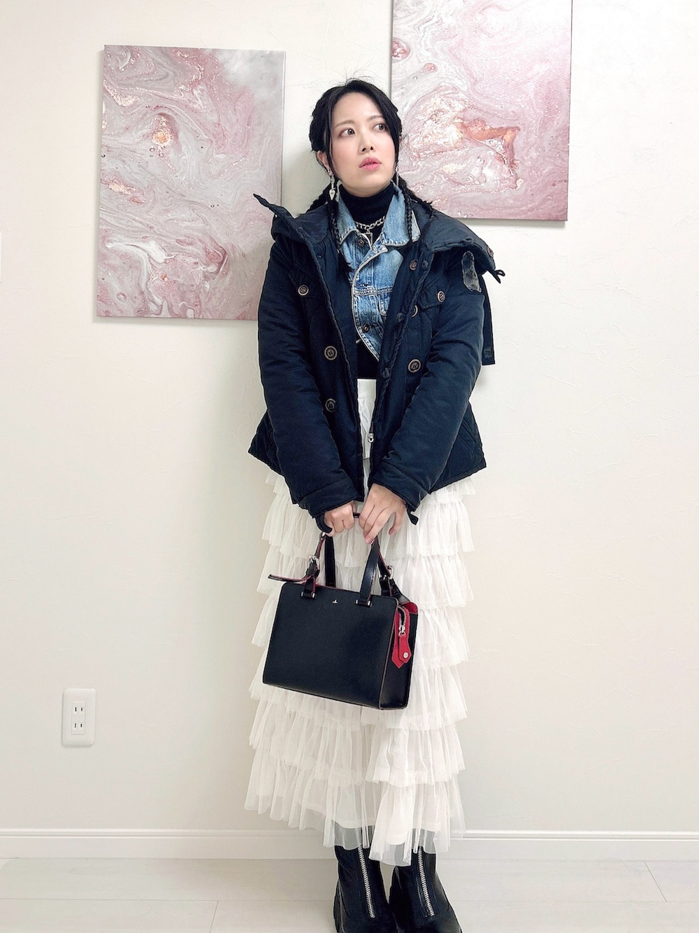 ブラック系のニット/セーター、ブルー系のデニムジャケット、ホワイト系のスカートを着用したレディースの冬コーディネートの2枚目の写真