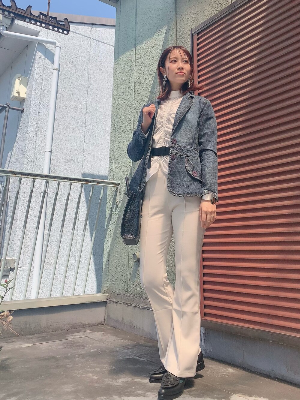 ホワイト系のシャツ/ブラウス、ホワイト系のスラックス、ブラック系のシューズを着用したレディースの春コーディネートの2枚目の写真