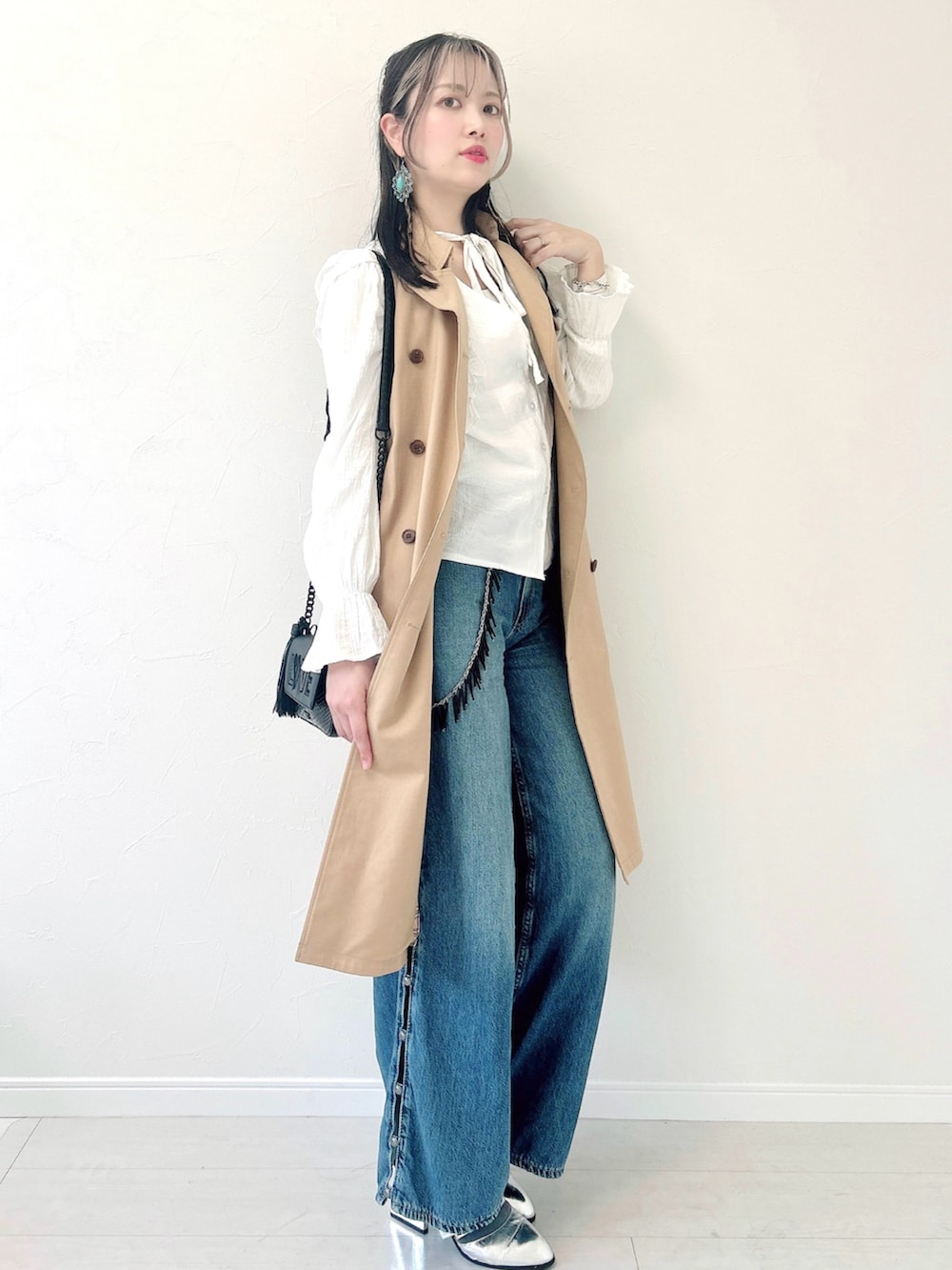 ブルー系のデニムパンツ、ホワイト系のシャツ/ブラウス、ベージュ系のトレンチコートを着用したレディースの春コーディネートの2枚目の写真