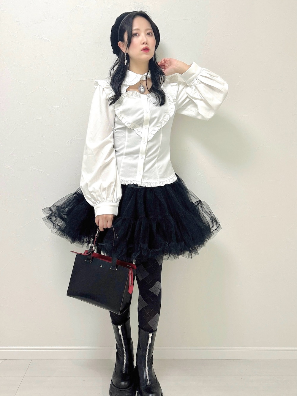 ホワイト系のシャツ/ブラウス、ブラック系のスカート、ブラック系のハンドバッグを着用したレディースの冬コーディネートの2枚目の写真
