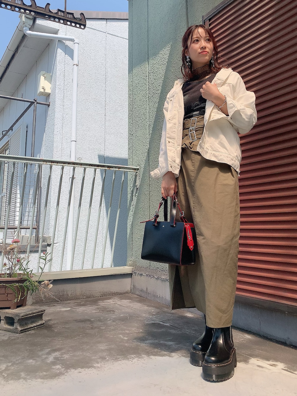 ブラック系のTシャツ/カットソー、グリーン系のスカート、ブラック系のブーツを着用したレディースの春コーディネートの2枚目の写真