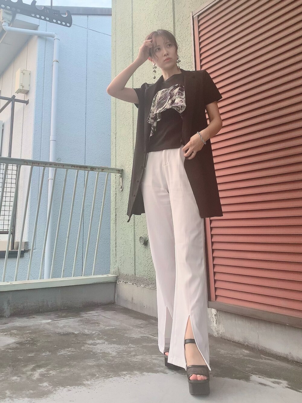 ブラック系のタンクトップ、ブラック系のジャケット/アウター、ホワイト系のスラックスを着用したレディースの夏コーディネートの2枚目の写真