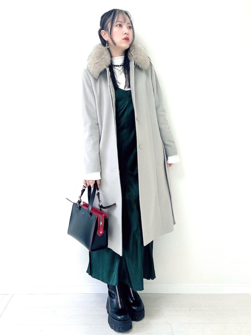 ホワイト系のTシャツ/カットソー、ブラック系のブーツ、グリーン系のワンピースを着用したレディースの冬コーディネートの2枚目の写真