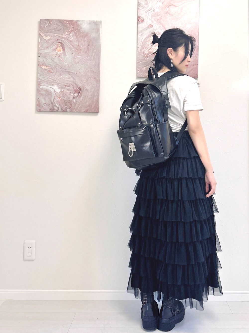 ホワイト系のTシャツ/カットソー、ブラック系のスカート、ブラック系のブーツを着用したレディースの夏コーディネートの2枚目の写真