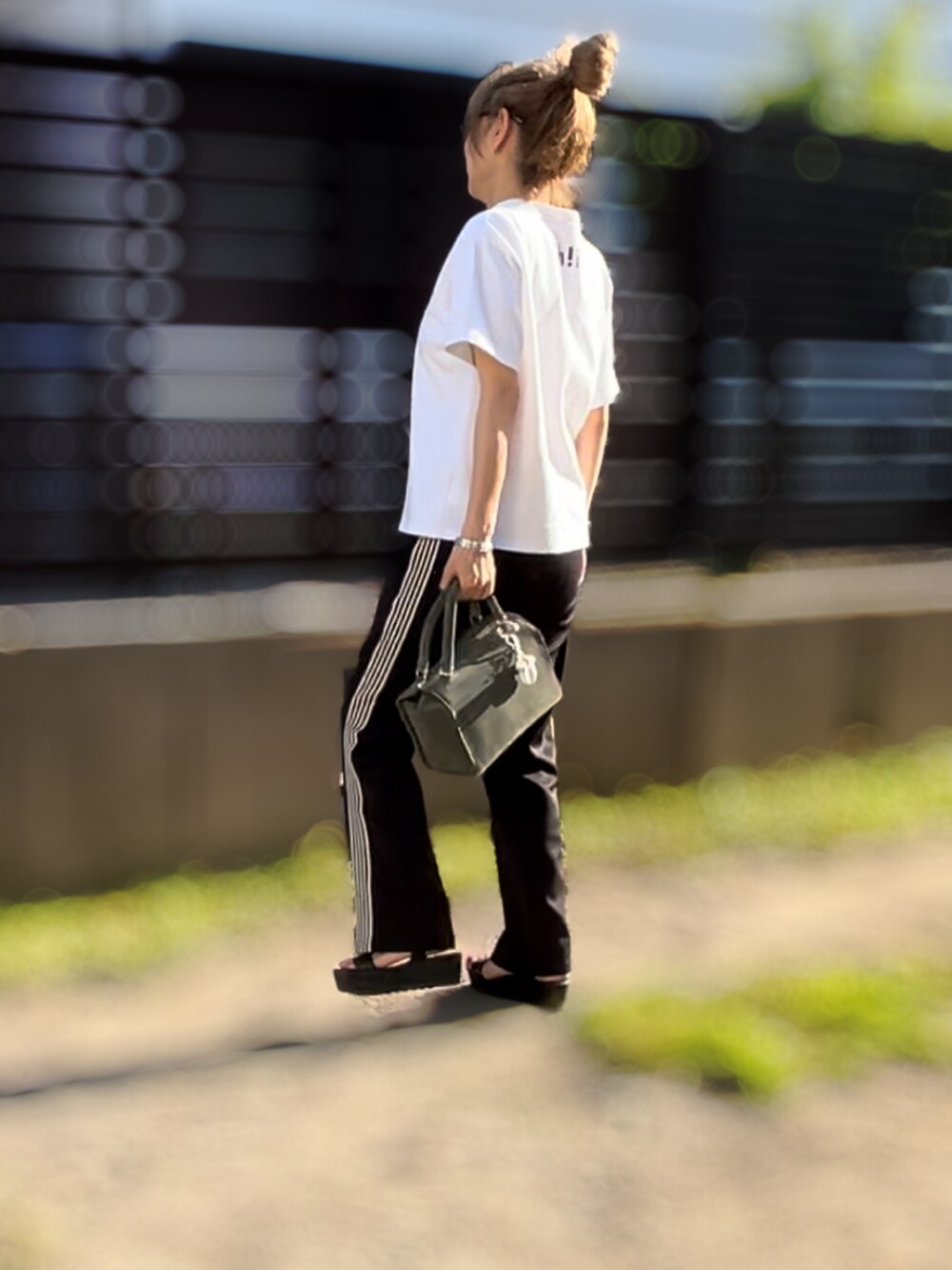 ホワイト系のTシャツ/カットソー、ブラック系のその他パンツ、ブラック系のサンダルを着用したレディースの夏コーディネートの2枚目の写真