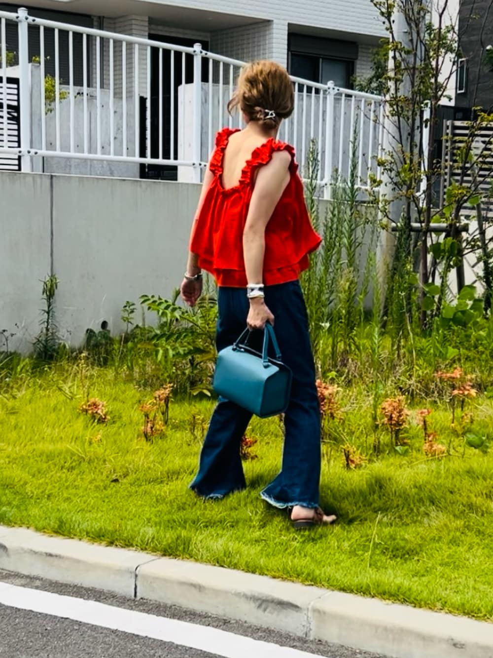 レッド系のキャミソールを着用したレディースの秋コーディネートの2枚目の写真