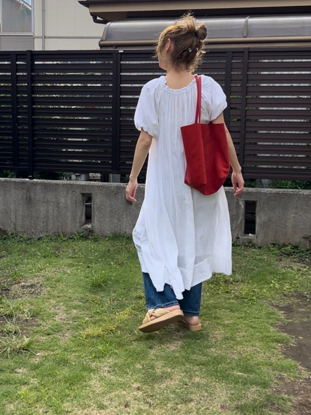 ホワイト系のワンピース、ブルー系のデニムパンツ、ベージュ系のサンダルを着用したレディースの夏コーディネートの4枚目の写真