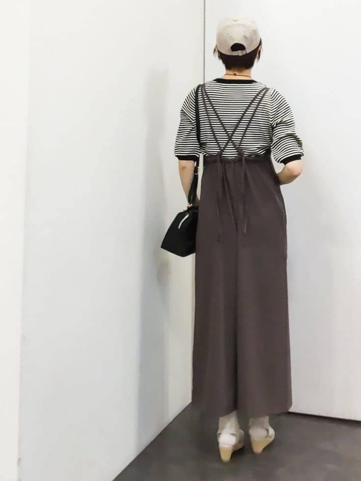 ブラウン系のサロペット/オーバーオール、ブラック系のニット/セーター、ブラック系のショルダーバッグを着用したレディースの春コーディネートの3枚目の写真