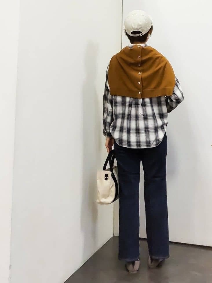 イエロー系のカーディガン/ボレロ、ホワイト系のシャツ/ブラウス、ブラック系のタンクトップを着用したレディースの秋コーディネートの3枚目の写真