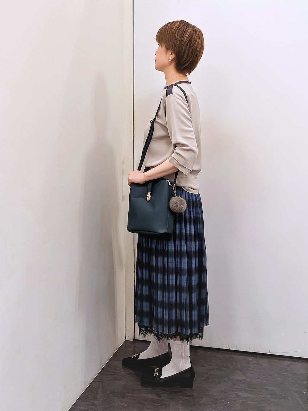 ベージュ系のニット/セーター、ホワイト系のTシャツ/カットソー、ブルー系のスカートを着用したレディースの秋コーディネートの2枚目の写真