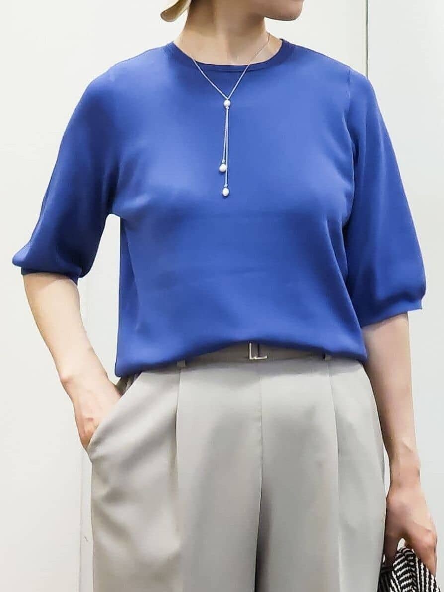 ブルー系のニット/セーター、ベージュ系のその他パンツ、ホワイト系のトートバッグを着用したレディースの春コーディネートの4枚目の写真
