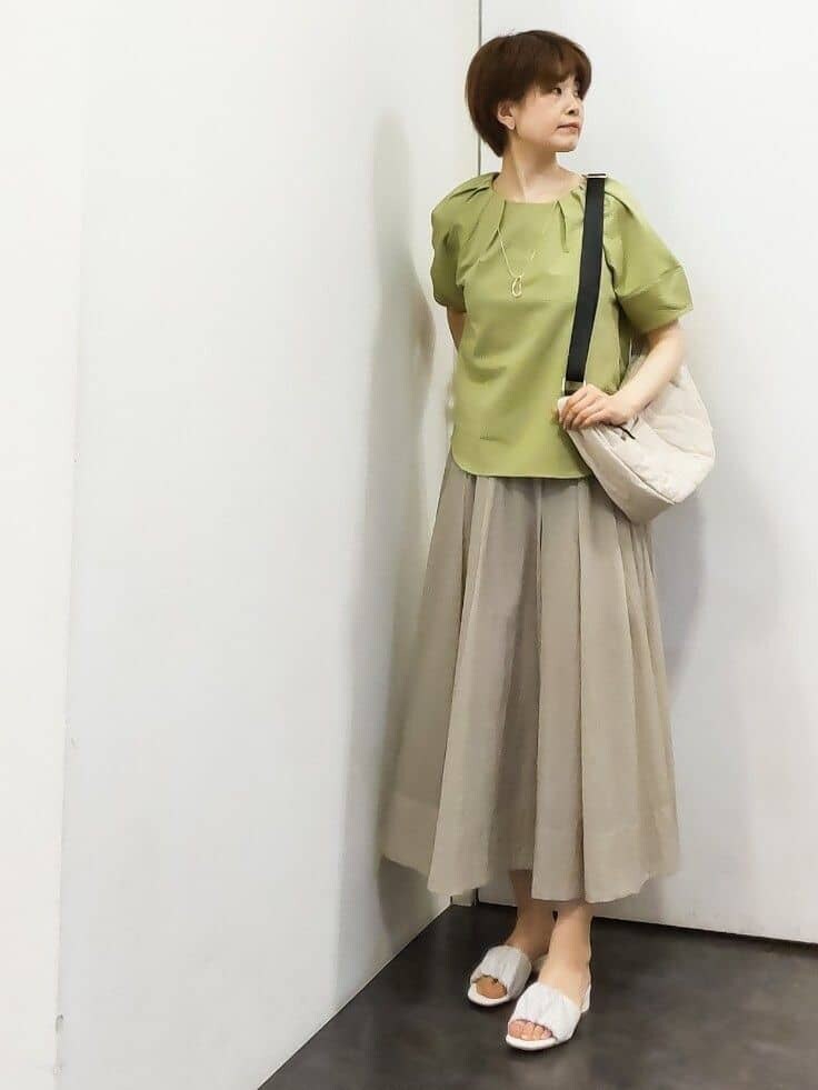 グリーン系のTシャツ/カットソー、ホワイト系のタンクトップ、ベージュ系のスカートを着用したレディースの夏コーディネートの5枚目の写真