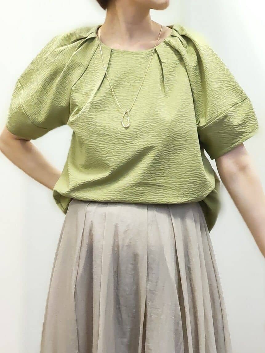 グリーン系のTシャツ/カットソー、ホワイト系のタンクトップ、ベージュ系のスカートを着用したレディースの夏コーディネートの4枚目の写真