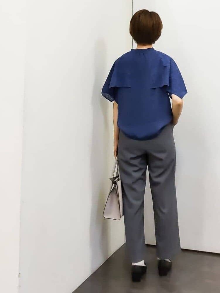 グレー系のトートバッグ、ゴールド系のイヤリングを着用したレディースの秋コーディネートの3枚目の写真