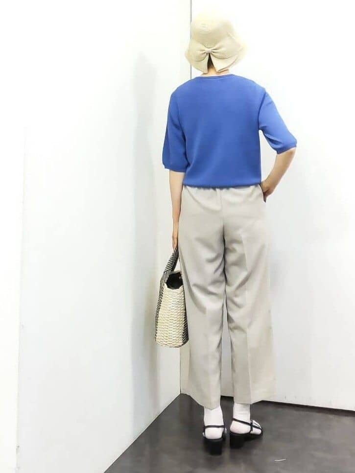 ブルー系のニット/セーター、ベージュ系のその他パンツ、ホワイト系のトートバッグを着用したレディースの春コーディネートの3枚目の写真