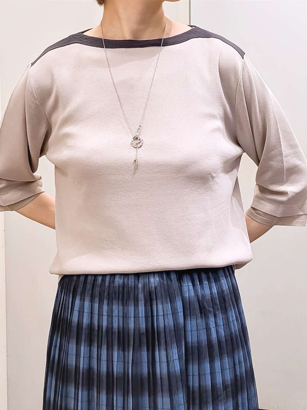 ベージュ系のニット/セーター、ホワイト系のTシャツ/カットソー、ブルー系のスカートを着用したレディースの秋コーディネートの4枚目の写真