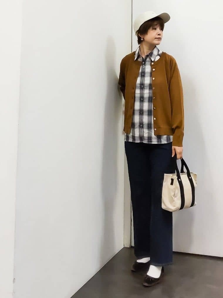 イエロー系のカーディガン/ボレロ、ホワイト系のシャツ/ブラウス、ブラック系のタンクトップを着用したレディースの秋コーディネートの6枚目の写真