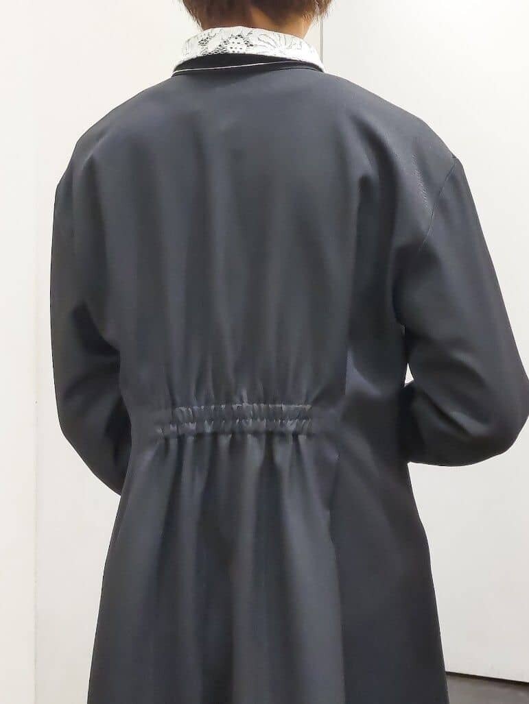 ホワイト系のノーカラージャケット、ブラック系のワンピース、ピンク系のハンドバッグを着用したレディースの冬コーディネートの7枚目の写真