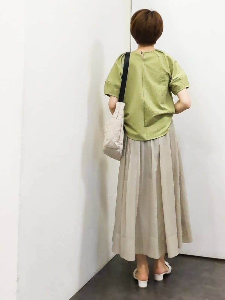 グリーン系のTシャツ/カットソー、ホワイト系のタンクトップ、ベージュ系のスカートを着用したレディースの夏コーディネートの3枚目の写真
