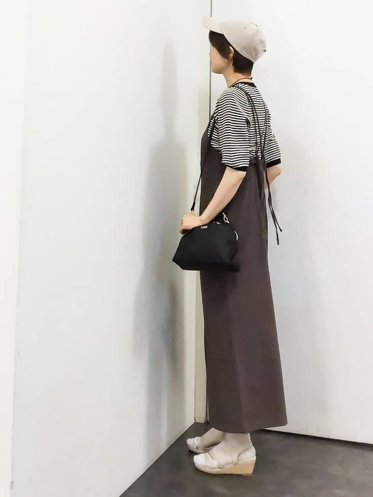 ブラウン系のサロペット/オーバーオール、ブラック系のニット/セーター、ブラック系のショルダーバッグを着用したレディースの春コーディネートの2枚目の写真