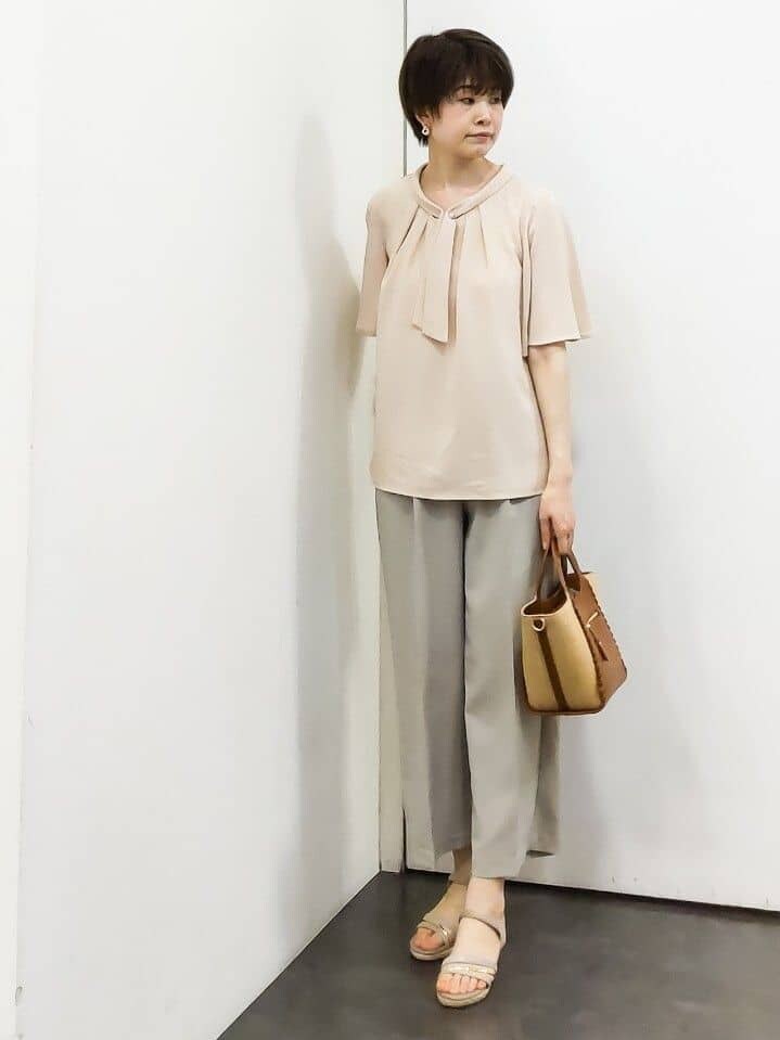 ピンク系のシャツ/ブラウス、ベージュ系のその他パンツ、イエロー系のトートバッグを着用したレディースの春コーディネートの4枚目の写真