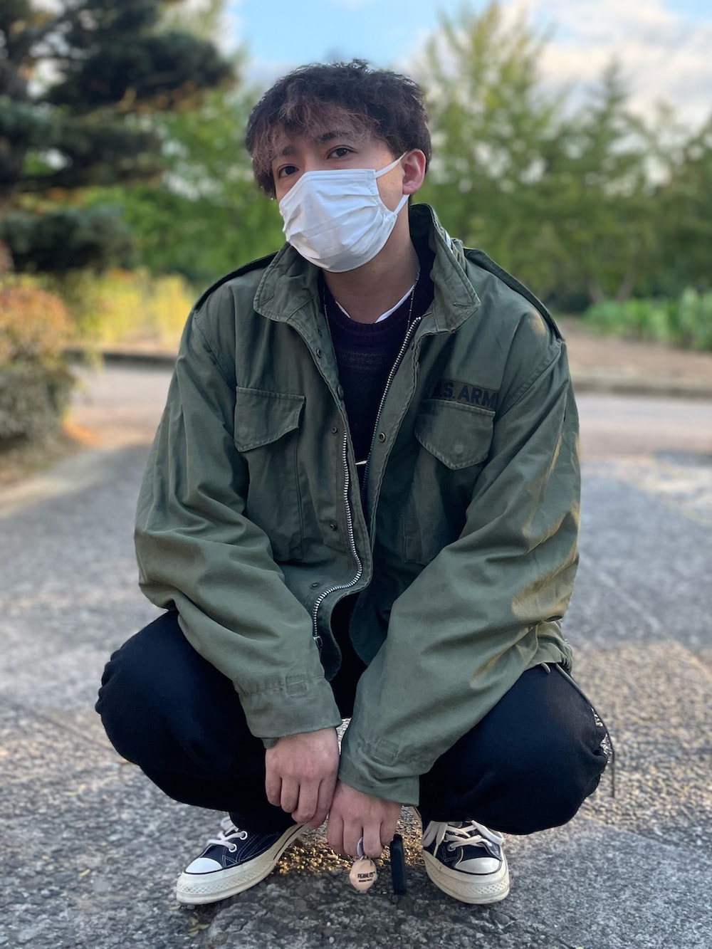 グリーン系のミリタリージャケット、パープル系のニット/セーター、ブラック系のデニムパンツを着用したメンズの秋コーディネートの3枚目の写真