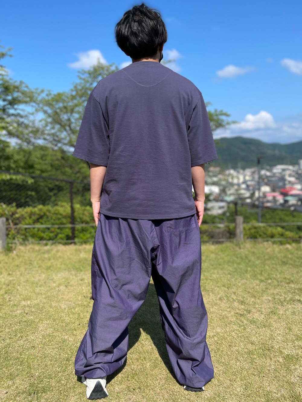 パープル系のTシャツ/カットソー、パープル系のパンツ、ホワイト系のスニーカーを着用したメンズの夏コーディネートの2枚目の写真