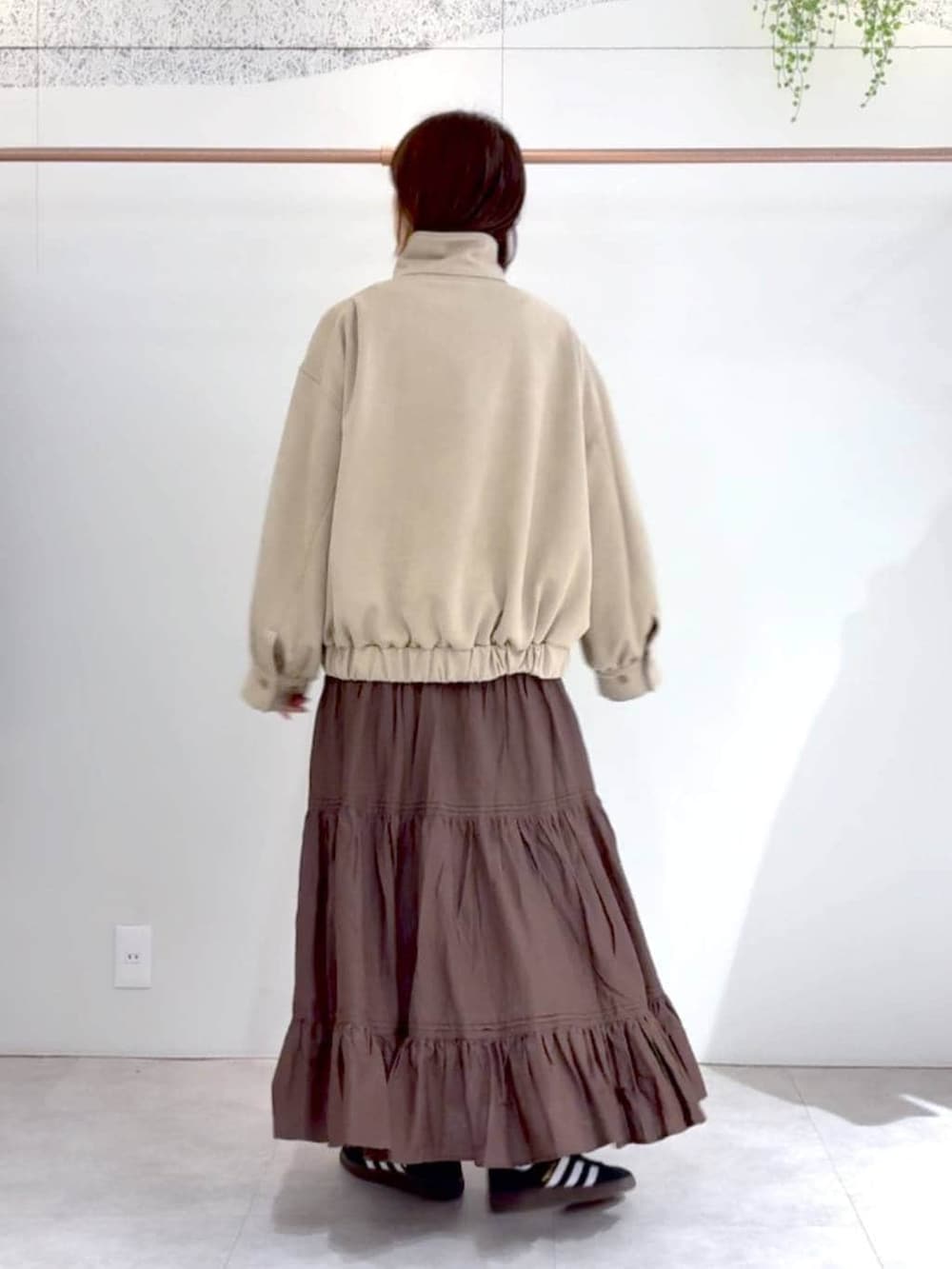 ブラック系のスニーカー、ベージュ系のブルゾンを着用したレディースの冬コーディネートの2枚目の写真