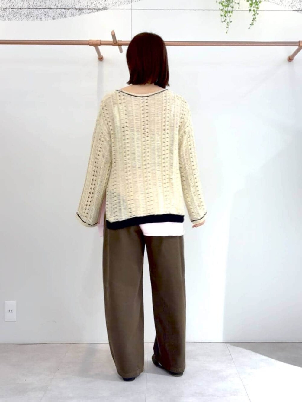 グリーン系のその他パンツ、ピンク系のTシャツ/カットソー、ベージュ系のニット/セーターを着用したレディースの春コーディネートの2枚目の写真