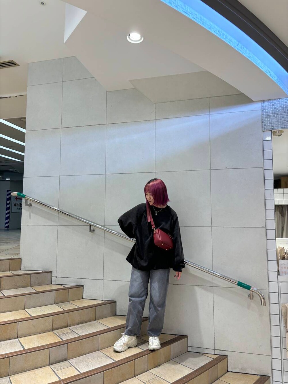 グレー系のデニムパンツ、ブラック系のTシャツ/カットソーを着用したレディースの秋コーディネートの2枚目の写真