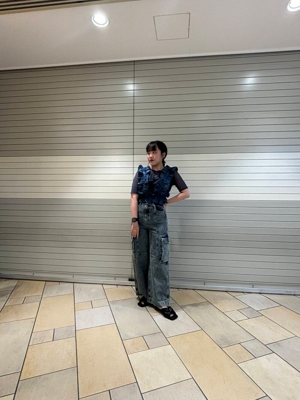 ブルー系のベスト、グレー系のTシャツ/カットソー、グレー系のデニムパンツを着用したレディースの夏コーディネートの2枚目の写真