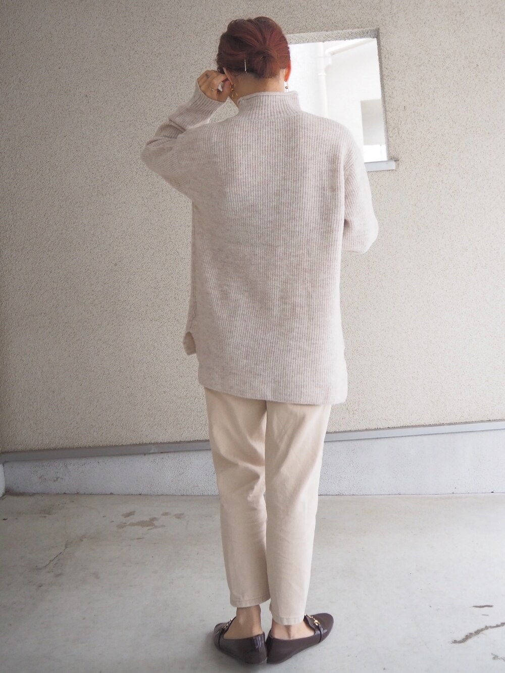 ホワイト系のニット/セーター、ブラウン系のレインシューズを着用したレディースの秋コーディネートの3枚目の写真