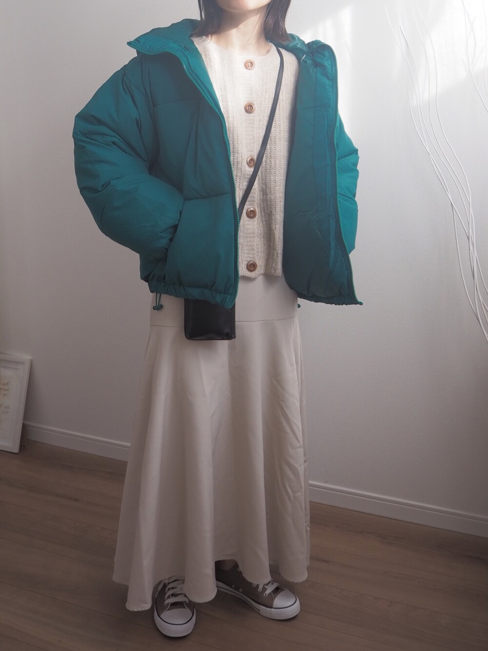 グリーン系のダウンジャケット/コート、ベージュ系のスカートを着用したレディースの冬コーディネートの3枚目の写真