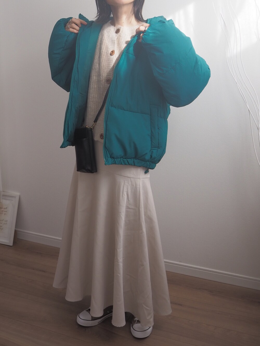 グリーン系のダウンジャケット/コート、ベージュ系のスカートを着用したレディースの冬コーディネートの4枚目の写真