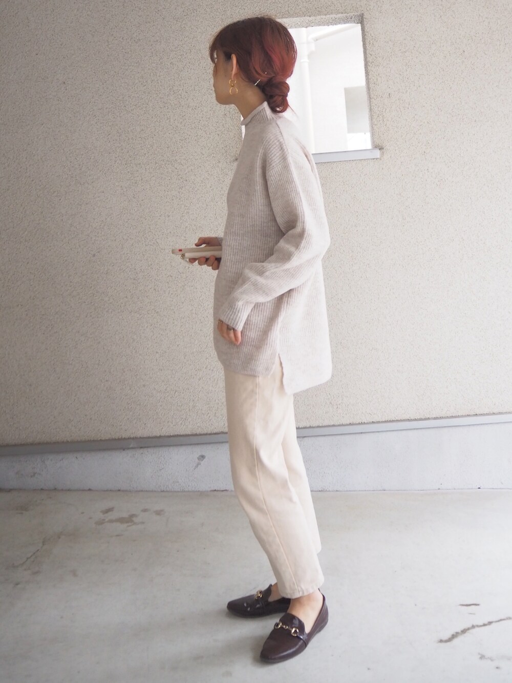 ホワイト系のニット/セーター、ブラウン系のレインシューズを着用したレディースの秋コーディネートの4枚目の写真