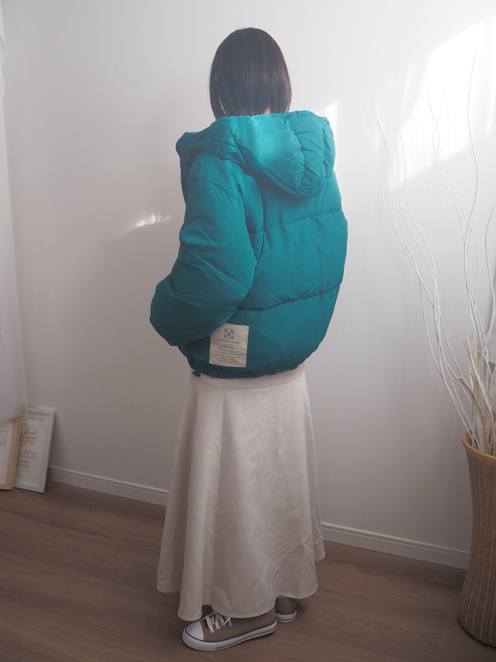 グリーン系のダウンジャケット/コート、ベージュ系のスカートを着用したレディースの冬コーディネートの2枚目の写真