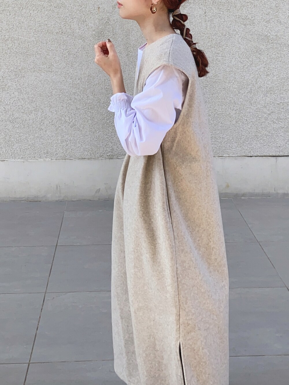 ベージュ系のワンピース、ブラック系のベスト、ブラウン系のレインシューズを着用したレディースの秋コーディネートの2枚目の写真