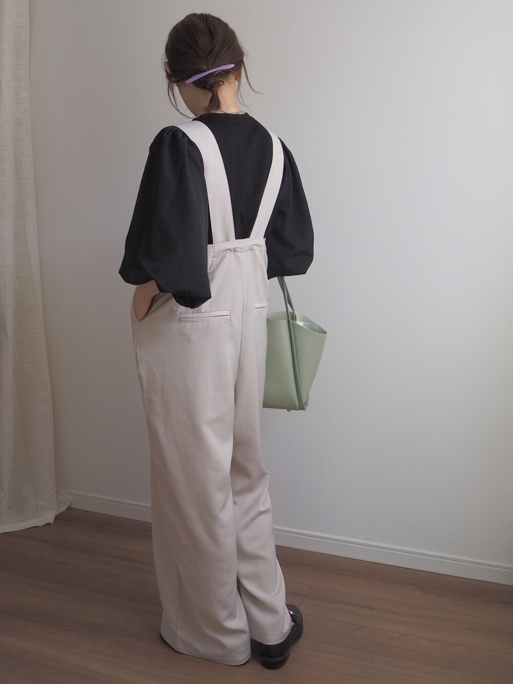 ブラック系のTシャツ/カットソー、ホワイト系のサロペット/オーバーオール、ブラック系のローファーを着用したレディースの春コーディネートの4枚目の写真