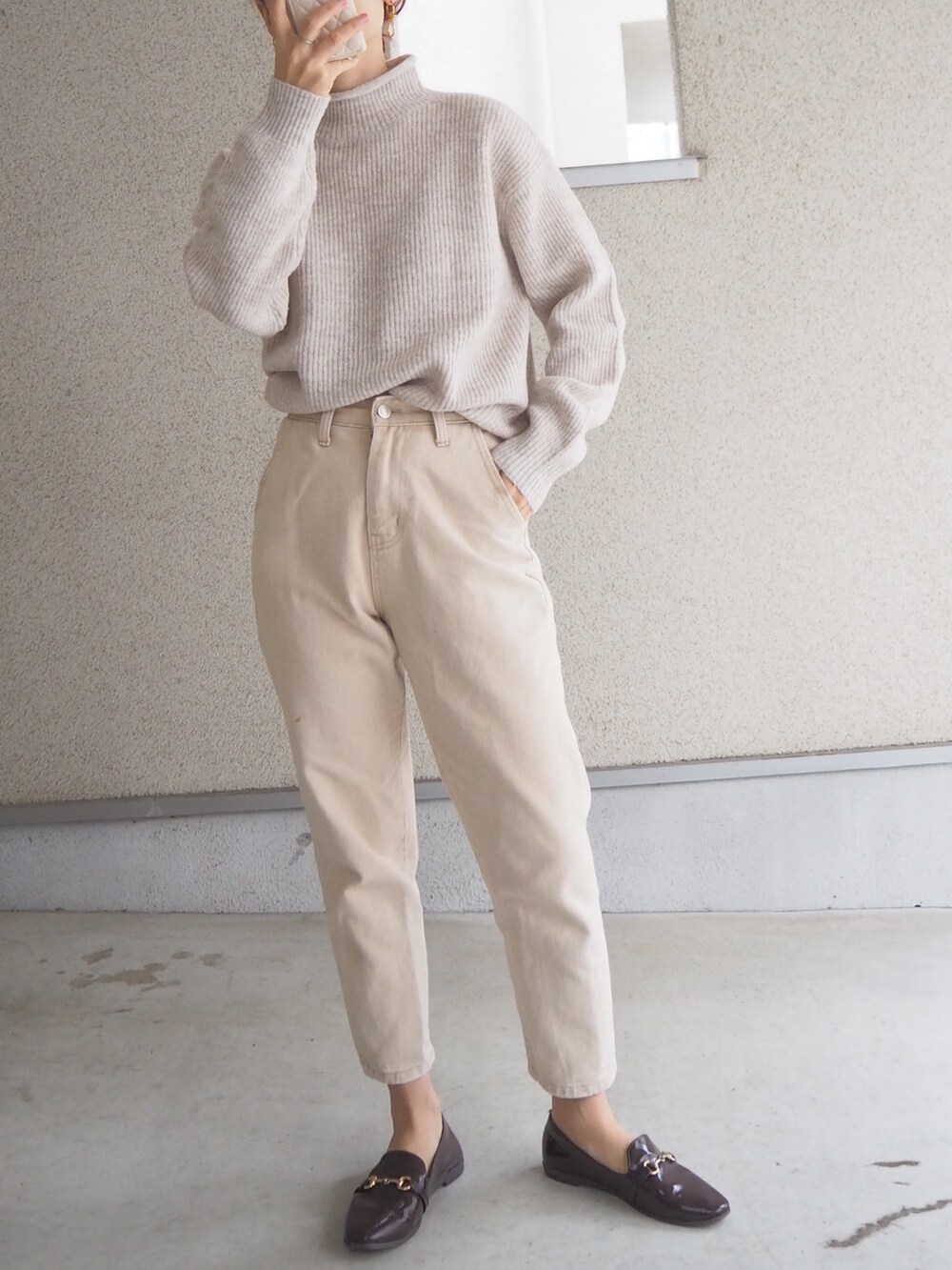 ホワイト系のニット/セーター、ブラウン系のレインシューズを着用したレディースの秋コーディネートの2枚目の写真