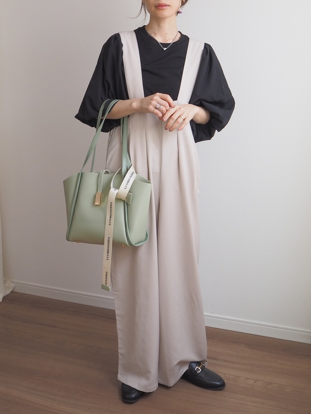 ブラック系のTシャツ/カットソー、ホワイト系のサロペット/オーバーオール、ブラック系のローファーを着用したレディースの春コーディネートの3枚目の写真