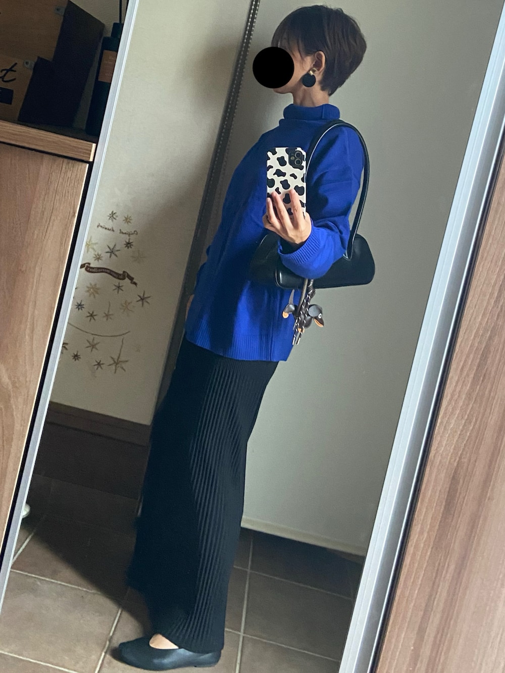 ブルー系のニット/セーター、ブラック系のスカート、ブラック系のバレエシューズを着用したレディースの秋コーディネートの2枚目の写真