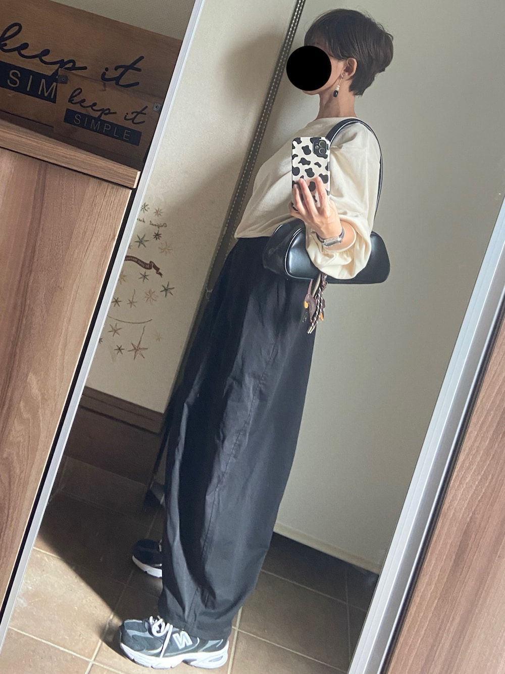 ホワイト系のスウェット、ブラック系のボストンバッグ、ブラック系のパンツを着用したレディースの秋コーディネートの3枚目の写真