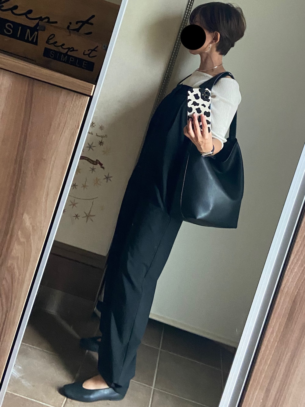 ブラック系のサロペット/オーバーオール、ホワイト系のニット/セーター、ブラック系のバレエシューズを着用したレディースの秋コーディネートの3枚目の写真