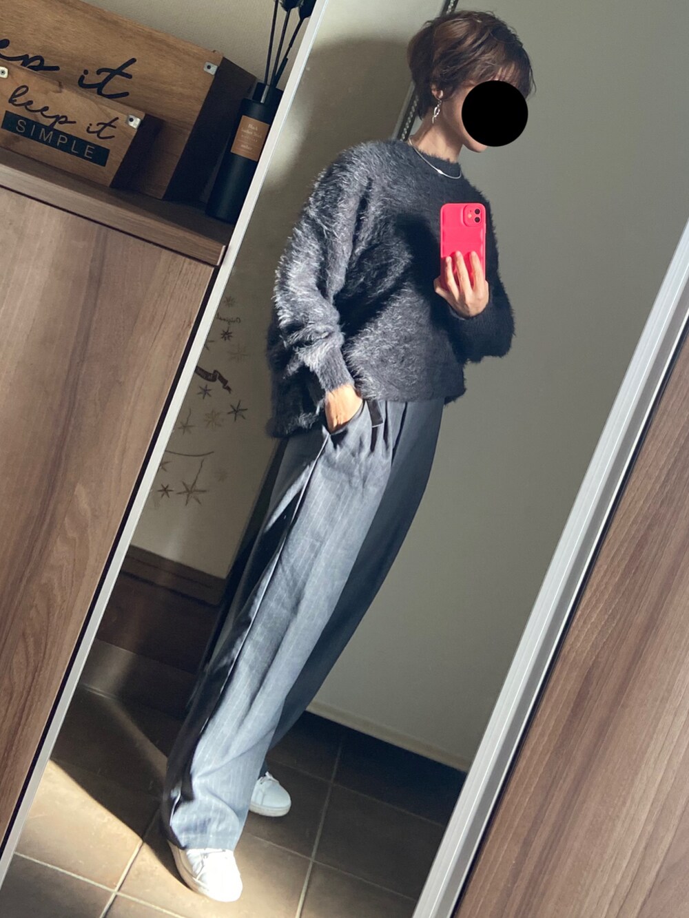 グレー系のスラックス、ホワイト系のスニーカー、ブラック系のニット/セーターを着用したレディースの冬コーディネートの2枚目の写真