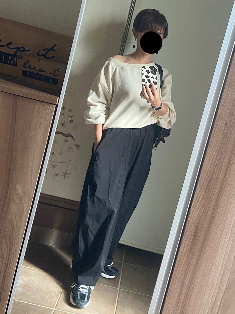 ホワイト系のスウェット、ブラック系のボストンバッグ、ブラック系のパンツを着用したレディースの秋コーディネートの2枚目の写真