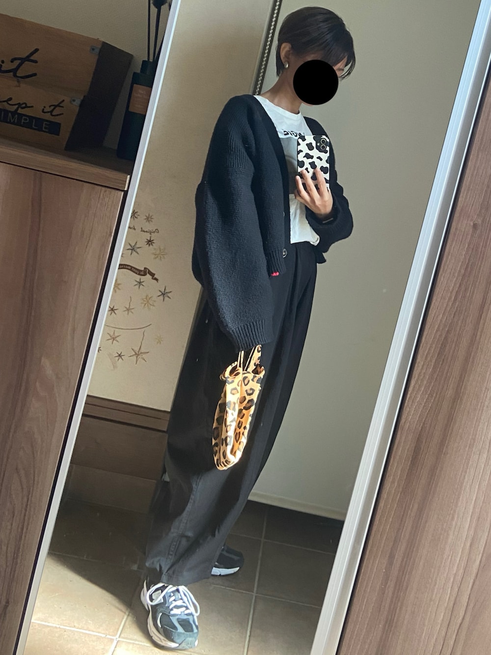 ホワイト系のTシャツ/カットソー、ブラック系のカーディガン/ボレロ、ブラック系のパンツを着用したレディースの秋コーディネートの3枚目の写真