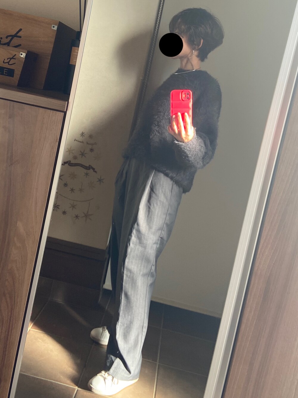 グレー系のスラックス、ホワイト系のスニーカー、ブラック系のニット/セーターを着用したレディースの冬コーディネートの3枚目の写真